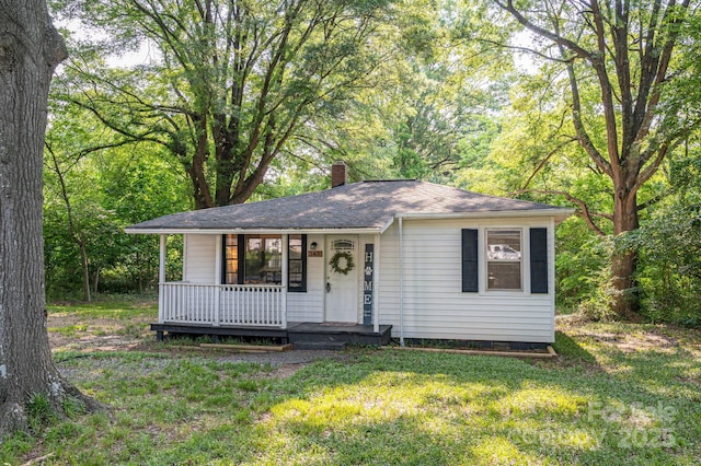 143 Hallman St, Cherryville, NC 28021 - view of front of house featuring covered porch, a chimney, a front lawn, and roof with shingles