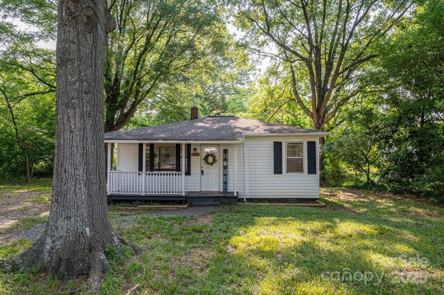 143 Hallman St, Cherryville, NC 28021 - view of front of home featuring a porch, a chimney, a front lawn, and roof with shingles