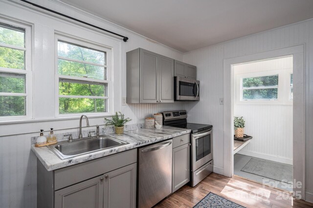 143 Hallman St, Cherryville, NC 28021 - kitchen featuring appliances with stainless steel finishes, gray cabinetry, a sink, crown molding, and light wood-style flooring
