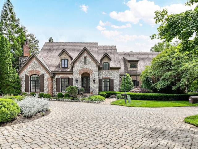 2240 La Maison Dr, Charlotte, NC 28226 - french country inspired facade featuring stone siding, a chimney, and curved driveway