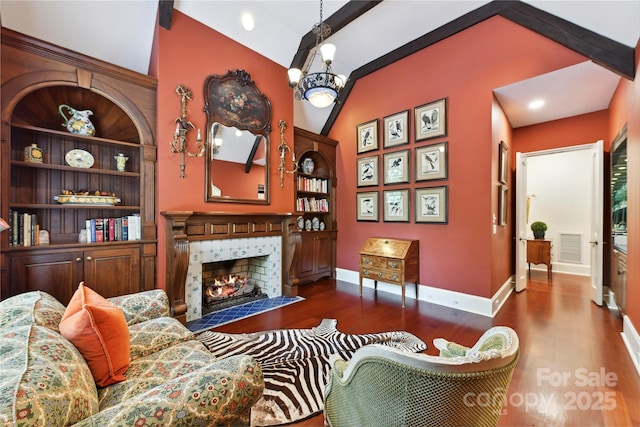 2240 La Maison Dr, Charlotte, NC 28226 - living room with vaulted ceiling, wood finished floors, a tiled fireplace, baseboards, and a chandelier