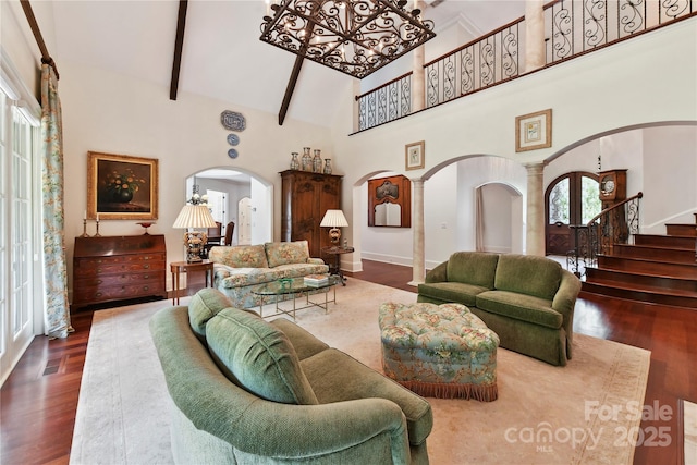 2240 La Maison Dr, Charlotte, NC 28226 - living area with arched walkways, high vaulted ceiling, wood finished floors, stairs, and beam ceiling