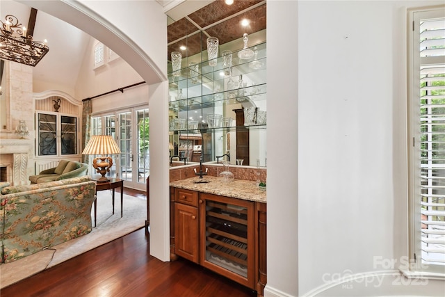 2240 La Maison Dr, Charlotte, NC 28226 - indoor wet bar with beverage cooler, dark wood-style flooring, arched walkways, and a towering ceiling