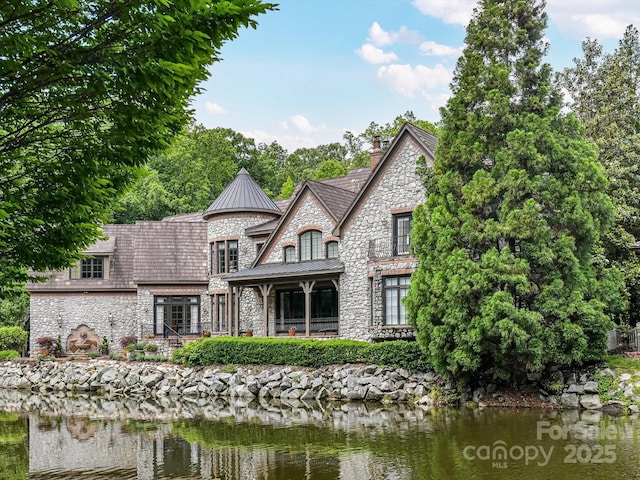 2240 La Maison Dr, Charlotte, NC 28226 - back of property featuring stone siding, a standing seam roof, a chimney, and a water view