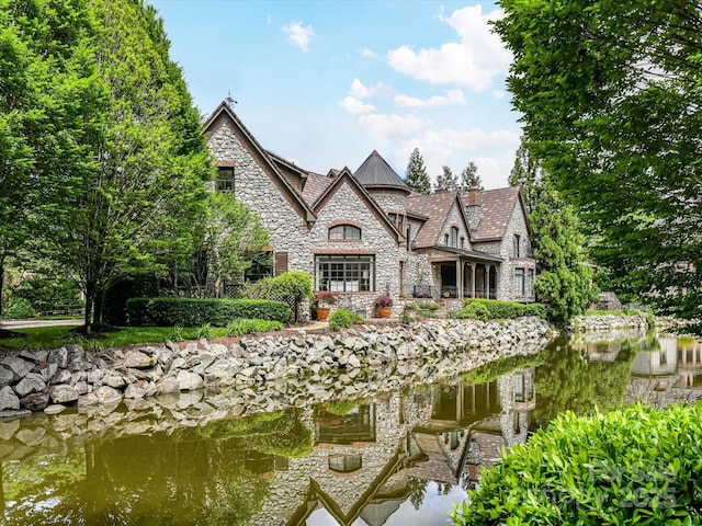 2240 La Maison Dr, Charlotte, NC 28226 - rear view of property with stone siding, a standing seam roof, and a water view