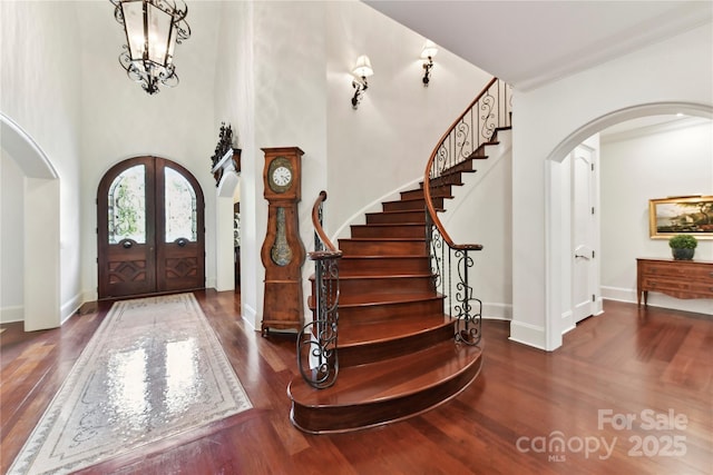 2240 La Maison Dr, Charlotte, NC 28226 - foyer featuring arched walkways, wood finished floors, french doors, stairway, and a towering ceiling