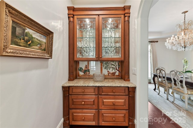 2240 La Maison Dr, Charlotte, NC 28226 - bar area with a chandelier, arched walkways, dark wood-style floors, and decorative light fixtures