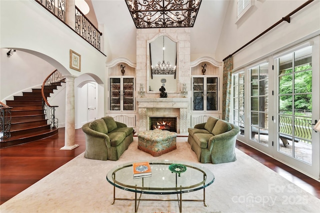 2240 La Maison Dr, Charlotte, NC 28226 - living room with a high ceiling, wood finished floors, arched walkways, stairs, and a fireplace
