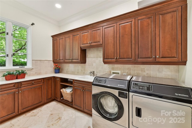 2240 La Maison Dr, Charlotte, NC 28226 - laundry area featuring washing machine and clothes dryer, cabinet space, light marble finish floors, and crown molding