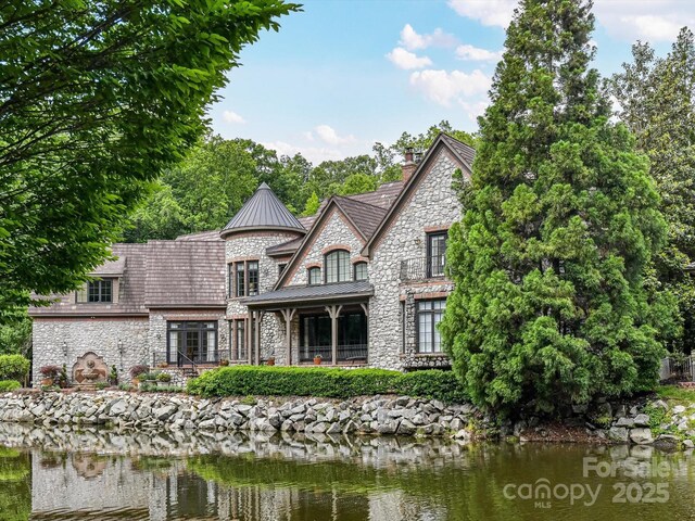 2240 La Maison Dr, Charlotte, NC 28226 - back of house featuring stone siding, a standing seam roof, a chimney, and a water view