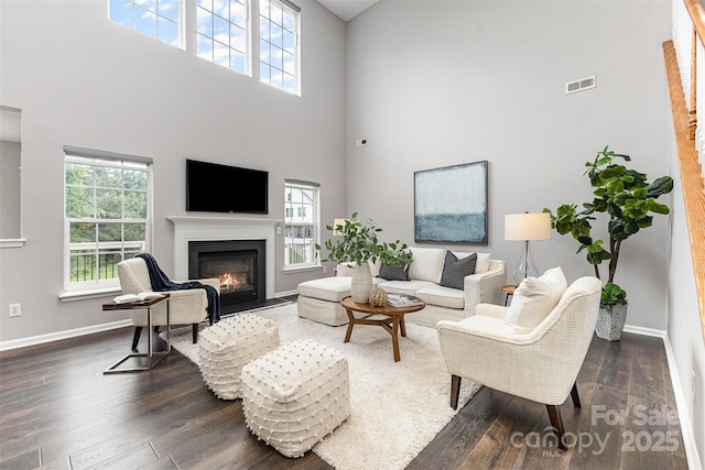 10198 Tintinhull Dr, Fort Mill, SC 29707 - living room with a towering ceiling, dark wood-type flooring, baseboards, and a glass covered fireplace
