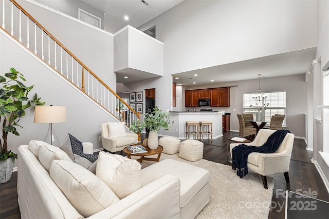 10198 Tintinhull Dr, Fort Mill, SC 29707 - living room featuring dark wood-type flooring, a chandelier, stairway, baseboards, and a high ceiling