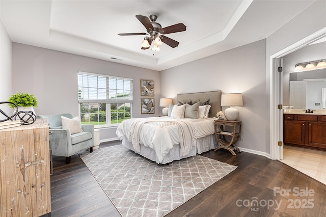 10198 Tintinhull Dr, Fort Mill, SC 29707 - bedroom with a raised ceiling, baseboards, ensuite bathroom, wood finished floors, and a sink