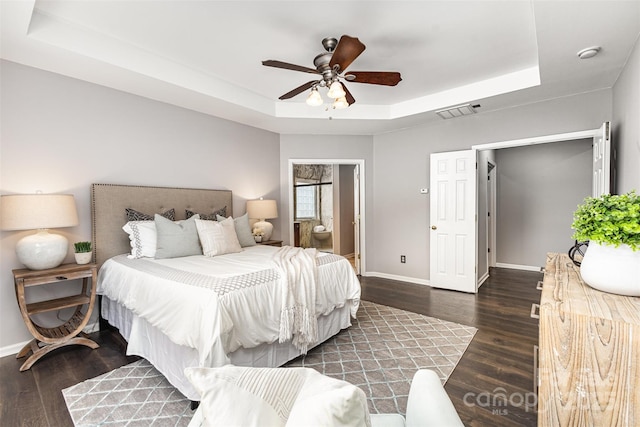 10198 Tintinhull Dr, Fort Mill, SC 29707 - bedroom featuring a tray ceiling, baseboards, wood finished floors, connected bathroom, and ceiling fan