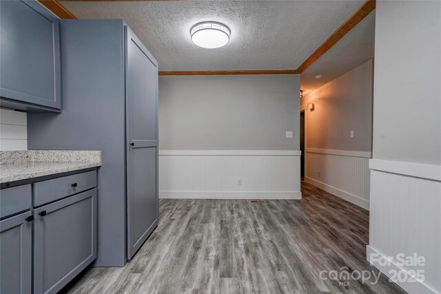 1010 Fallston Rd, Shelby, NC 28150 - unfurnished dining area with wood finished floors, wainscoting, and a textured ceiling