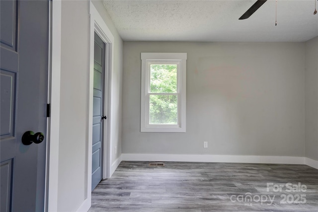 1010 Fallston Rd, Shelby, NC 28150 - unfurnished room featuring ceiling fan, wood finished floors, baseboards, and a textured ceiling