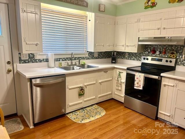 1014 Wright St SW Unit # 4, Lenoir, NC 28645 - kitchen featuring appliances with stainless steel finishes, under cabinet range hood, tasteful backsplash, white cabinetry, and crown molding