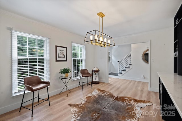 1119 Thornsby Ln, Matthews, NC 28105 - sitting room featuring stairs, plenty of natural light, a chandelier, ornamental molding, and wood finished floors