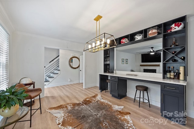 1119 Thornsby Ln, Matthews, NC 28105 - bar area featuring stairs, light wood-style floors, crown molding, a ceiling fan, and pendant lighting