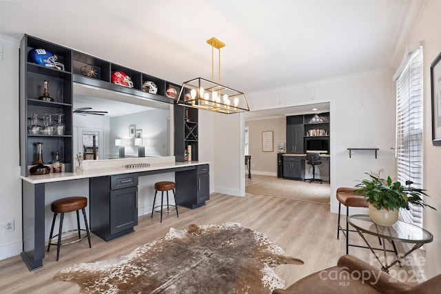 1119 Thornsby Ln, Matthews, NC 28105 - bar area with light wood finished floors, ornamental molding, hanging light fixtures, baseboards, and a chandelier