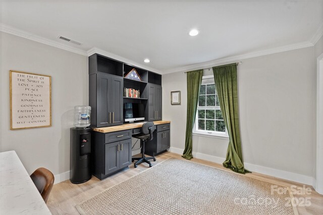 1119 Thornsby Ln, Matthews, NC 28105 - home office featuring crown molding, baseboards, light wood-style flooring, built in study area, and recessed lighting
