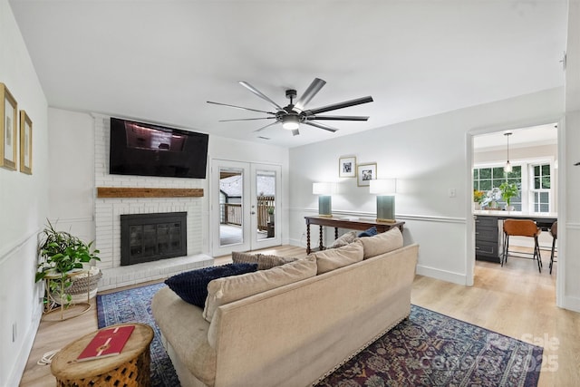 1119 Thornsby Ln, Matthews, NC 28105 - living room featuring light wood-style flooring, ceiling fan, a fireplace, and baseboards