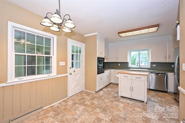 1961 Runnymede Ln, Charlotte, NC 28211 - kitchen featuring dishwasher, a baseboard heating unit, a sink, and stone finish flooring