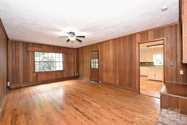 1961 Runnymede Ln, Charlotte, NC 28211 - unfurnished room featuring a sink, a ceiling fan, light wood-type flooring, wood walls, and baseboards