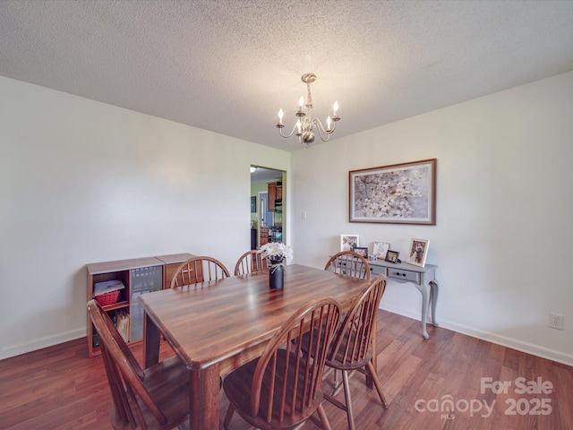 1060 S Lentz Harness Shop Rd, Mount Pleasant, NC 28124 - dining area with a chandelier, wood finished floors, baseboards, and a textured ceiling