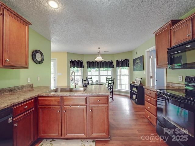 1060 S Lentz Harness Shop Rd, Mount Pleasant, NC 28124 - kitchen featuring black appliances, a sink, a textured ceiling, a peninsula, and wood finished floors