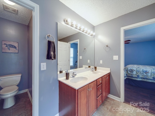 1060 S Lentz Harness Shop Rd, Mount Pleasant, NC 28124 - bathroom with connected bathroom, a textured ceiling, double vanity, toilet, and baseboards