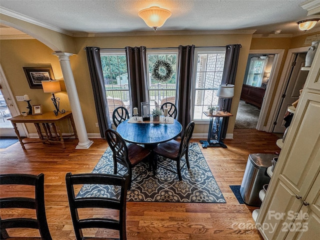 3273 16th St NE, Hickory, NC 28601 - dining space featuring ornate columns, arched walkways, light wood-style floors, plenty of natural light, and a textured ceiling