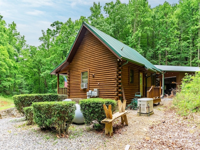 125 Cypress Ln, Saluda, NC 28773 - view of side of home featuring log exterior, a wooded view, metal roof, and cooling unit