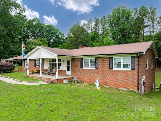 310 Yarbro Rd, Kings Mountain, NC 28086 - ranch-style home featuring brick siding, a front lawn, view of scattered trees, a chimney, and covered porch