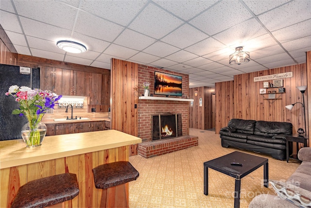 310 Yarbro Rd, Kings Mountain, NC 28086 - living room featuring wooden walls, a brick fireplace, light carpet, and a paneled ceiling
