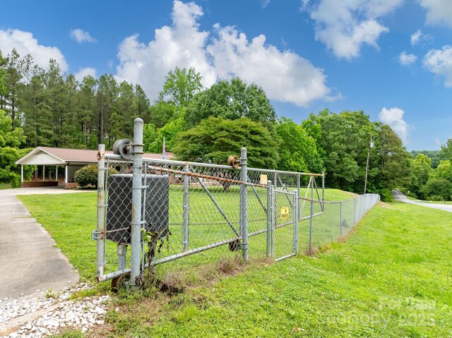 310 Yarbro Rd, Kings Mountain, NC 28086 - view of yard with asphalt driveway, a gate, cooling unit, a carport, and a forest view