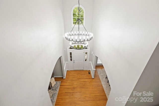 11139 Tradition View Dr, Charlotte, NC 28269 - foyer entrance with a chandelier, light wood-style flooring, arched walkways, a high ceiling, and baseboards