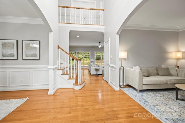 11139 Tradition View Dr, Charlotte, NC 28269 - entrance foyer featuring wood finished floors, ceiling fan, crown molding, arched walkways, and stairs