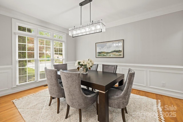 11139 Tradition View Dr, Charlotte, NC 28269 - dining area featuring a wainscoted wall, crown molding, a decorative wall, and light wood-type flooring