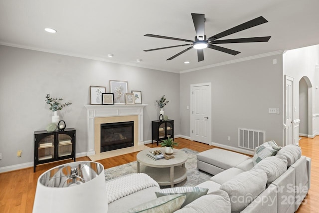 11139 Tradition View Dr, Charlotte, NC 28269 - living area featuring arched walkways, ceiling fan, a fireplace with flush hearth, ornamental molding, and recessed lighting