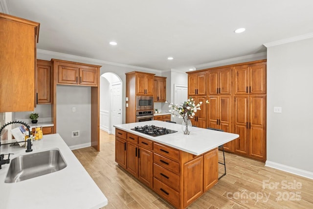 11139 Tradition View Dr, Charlotte, NC 28269 - kitchen featuring appliances with stainless steel finishes, a sink, arched walkways, brown cabinetry, and a center island