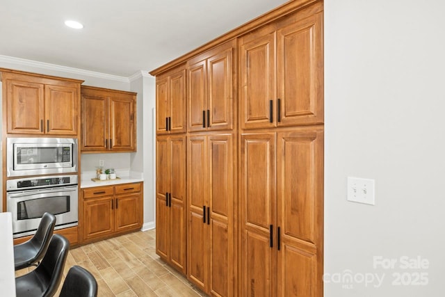 11139 Tradition View Dr, Charlotte, NC 28269 - kitchen with appliances with stainless steel finishes, brown cabinets, light countertops, crown molding, and light wood-style flooring