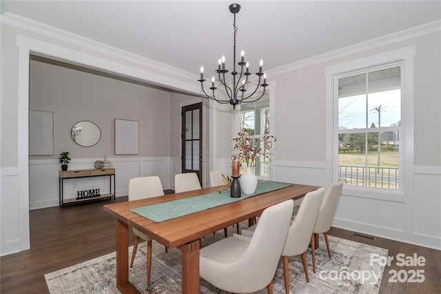 332 Canvasback Rd, Mooresville, NC 28117 - dining room featuring a chandelier, a decorative wall, dark wood-type flooring, wainscoting, and ornamental molding