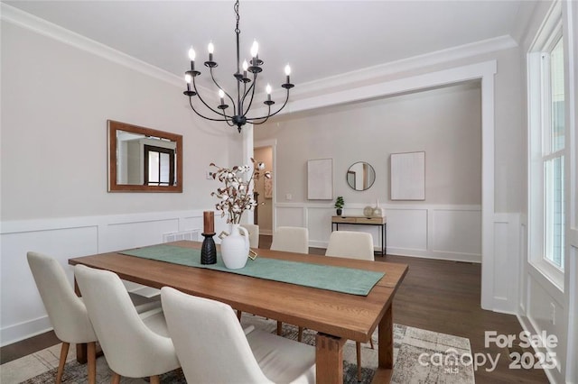 332 Canvasback Rd, Mooresville, NC 28117 - dining area featuring a chandelier, crown molding, a decorative wall, dark wood-type flooring, and a wainscoted wall