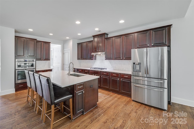 2785 Disney Pl, Indian Land, SC 29707 - kitchen with stainless steel appliances, a sink, light countertops, a breakfast bar area, and backsplash