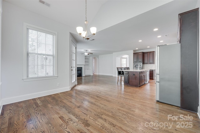 2785 Disney Pl, Indian Land, SC 29707 - kitchen featuring freestanding refrigerator, open floor plan, a chandelier, arched walkways, and a breakfast bar area