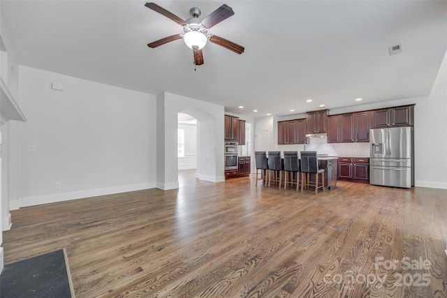 2785 Disney Pl, Indian Land, SC 29707 - kitchen with stainless steel appliances, a ceiling fan, arched walkways, a kitchen bar, and open floor plan