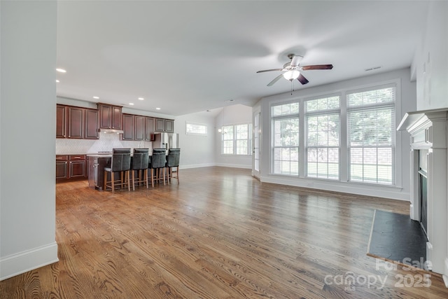 2785 Disney Pl, Indian Land, SC 29707 - unfurnished living room with a ceiling fan, a fireplace, baseboards, light wood finished floors, and vaulted ceiling
