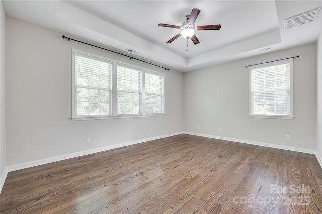 2785 Disney Pl, Indian Land, SC 29707 - unfurnished room featuring a tray ceiling, dark wood-type flooring, a ceiling fan, and healthy amount of natural light