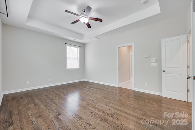 2785 Disney Pl, Indian Land, SC 29707 - spare room featuring a tray ceiling, a ceiling fan, wood finished floors, and baseboards